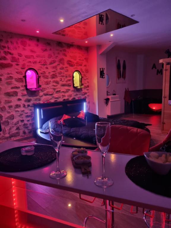 Le Rêve de Lily في Les Vignères: غرفة معيشة مع طاولة وكأسين للنبيذ
