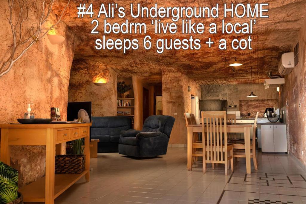 a living room with a table and a kitchen at Ali's Underground Home in Coober Pedy