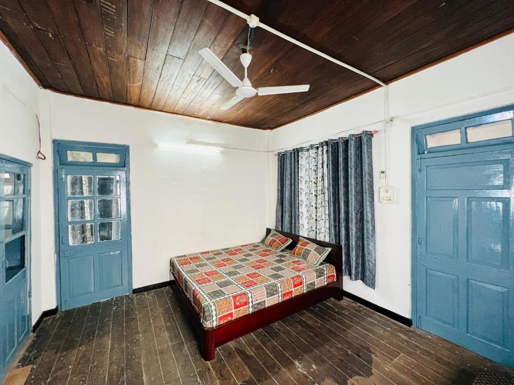a bedroom with a bed and two doors at Levi Home Guest House & Retreat Centre in Siliguri