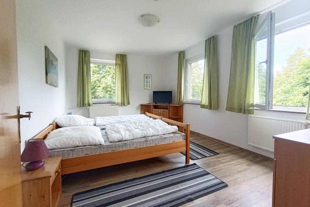 a bedroom with a bed and two windows at Ferienwohnung Gartenblick in Wesenberg