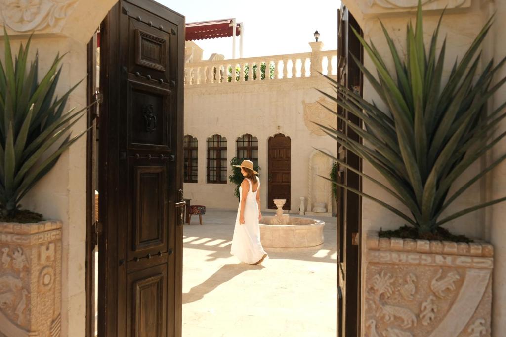 a woman in a white dress standing in a courtyard at Abraham Otel in Urfa