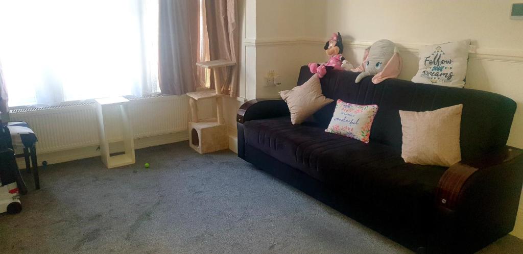 Ema apartment في لندن: غرفة معيشة مع أريكة سوداء مع وسائد