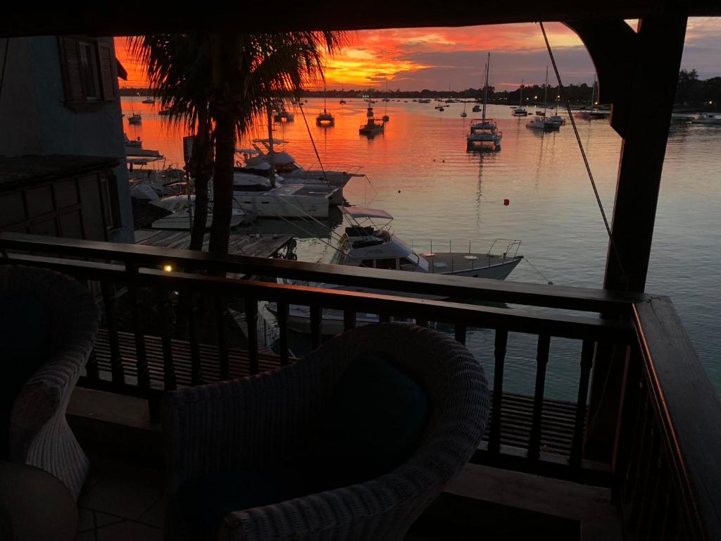 a view of a marina at sunset with a chair at Grand Baie Beach Penthouse in Grand Baie