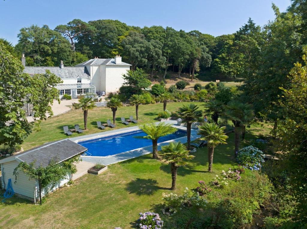 una vista aérea de una casa con piscina y árboles en Red River Stables - Peaceful, beautiful grounds, swimming pool, central location for West Cornwall en Camborne