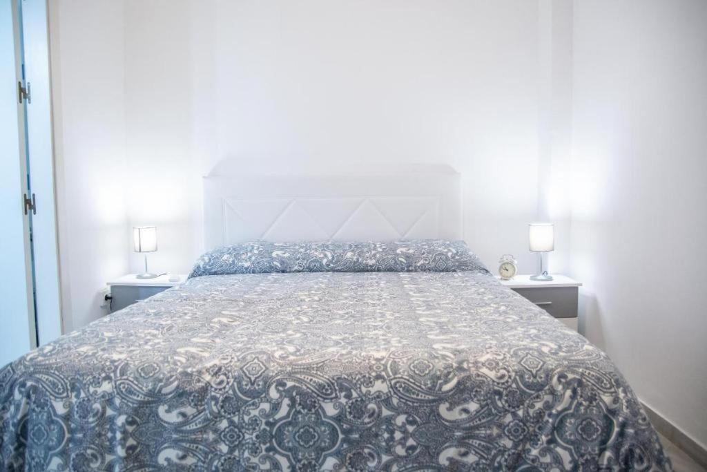 1 dormitorio con 1 cama con edredón azul y blanco en Casa Santa Clara Street, en Sevilla