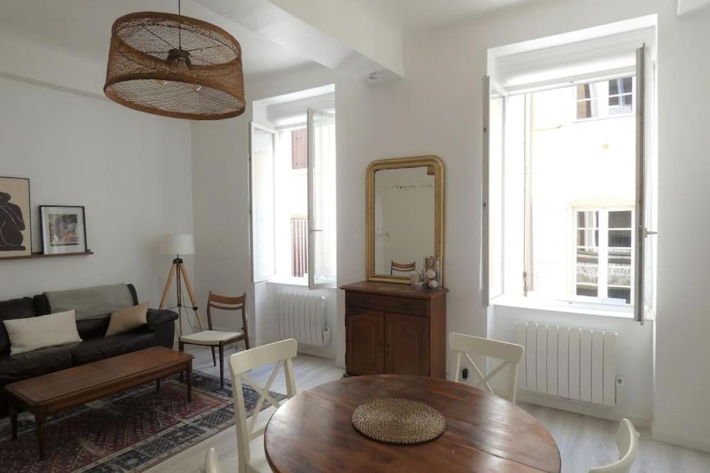 Una sala de estar con una mesa y un espejo. en Elegant, Spacious Apartment in Historic Center of Tournon, en Tournon-sur-Rhône