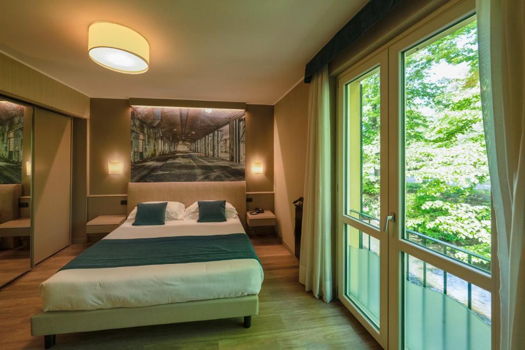 a bedroom with a bed and a large window at La Casa del Mulino in Merone