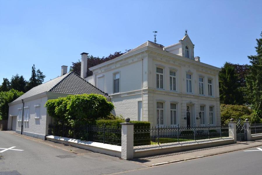una casa blanca con una valla delante en B&B Huis Spaas, en Neerpelt