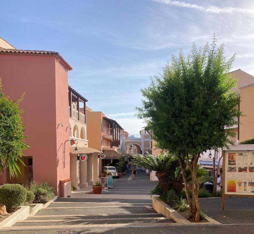 a street in a town with a tree and buildings at L&#39;écrin du Cap Esterel in Saint-Raphaël