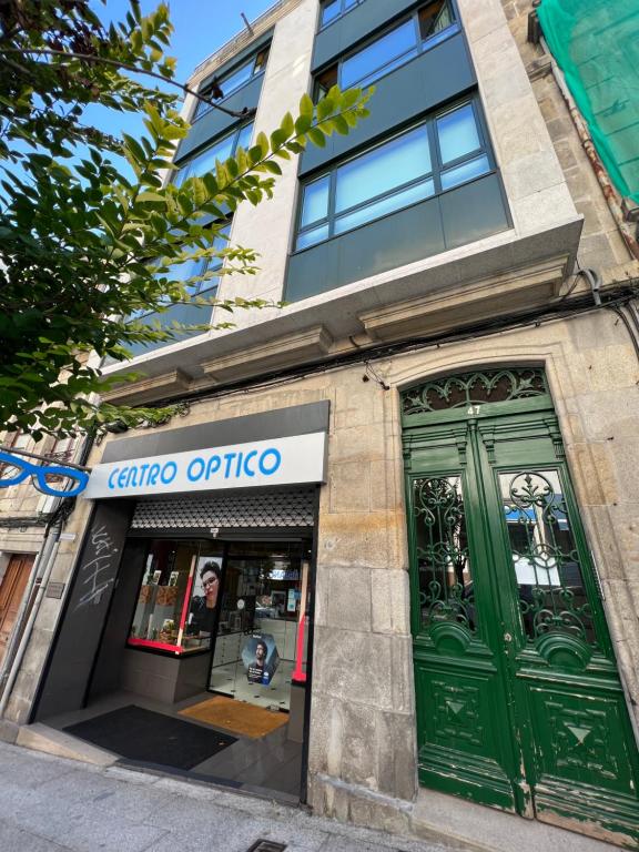 una tienda con puertas verdes en un edificio en The Red Flat - Estudio Boutique - Centro Ciudad, en Vigo