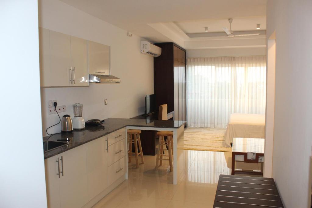 a kitchen with a counter and a dining room at Ocean Breeze Sea View Apartments in Negombo