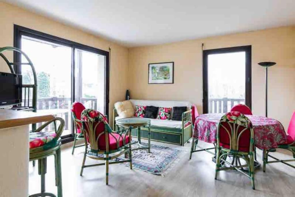 - un salon avec des chaises, une table et un canapé dans l'établissement Très bel appartement de Standing a 300 mètres de la mer, et à proximité du casino de Deauville, à Tourgéville