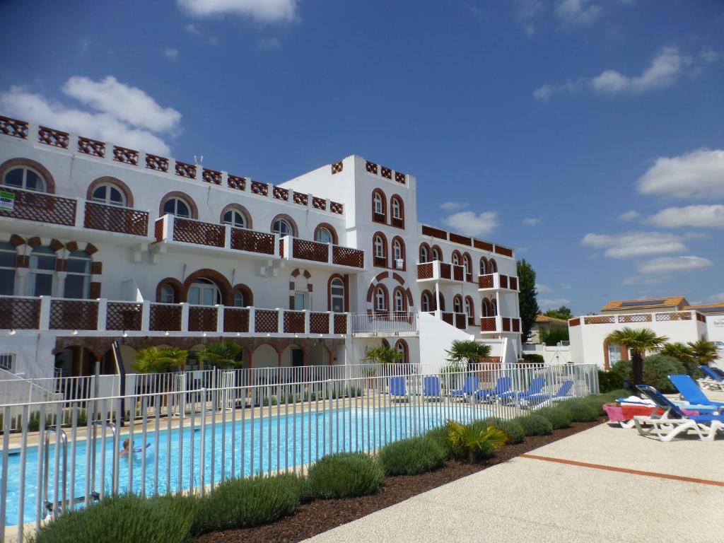 um hotel com piscina em frente a um edifício em Appartement bord de plage Tranche s/mer em La Tranche-sur-Mer