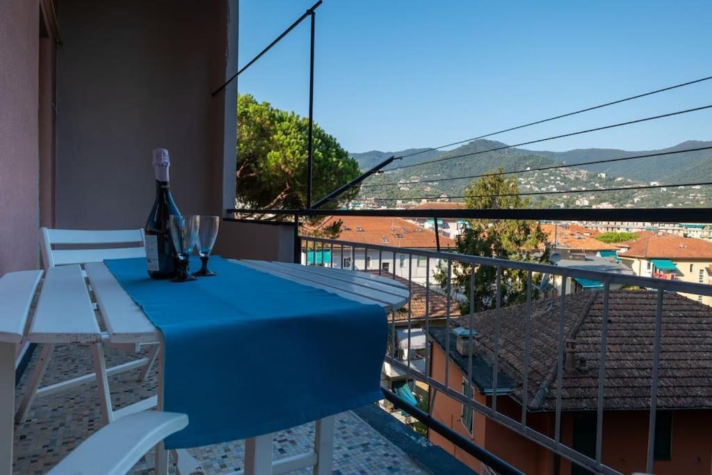 una mesa con una botella de vino y copas en el balcón en Noemi House en Rapallo