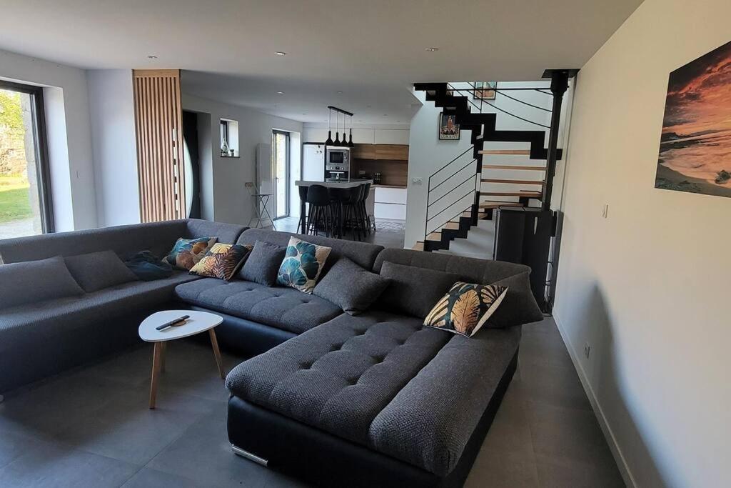 - un salon avec un canapé bleu et un escalier dans l'établissement Longère en pierre - 5 personnes, à Plouhinec