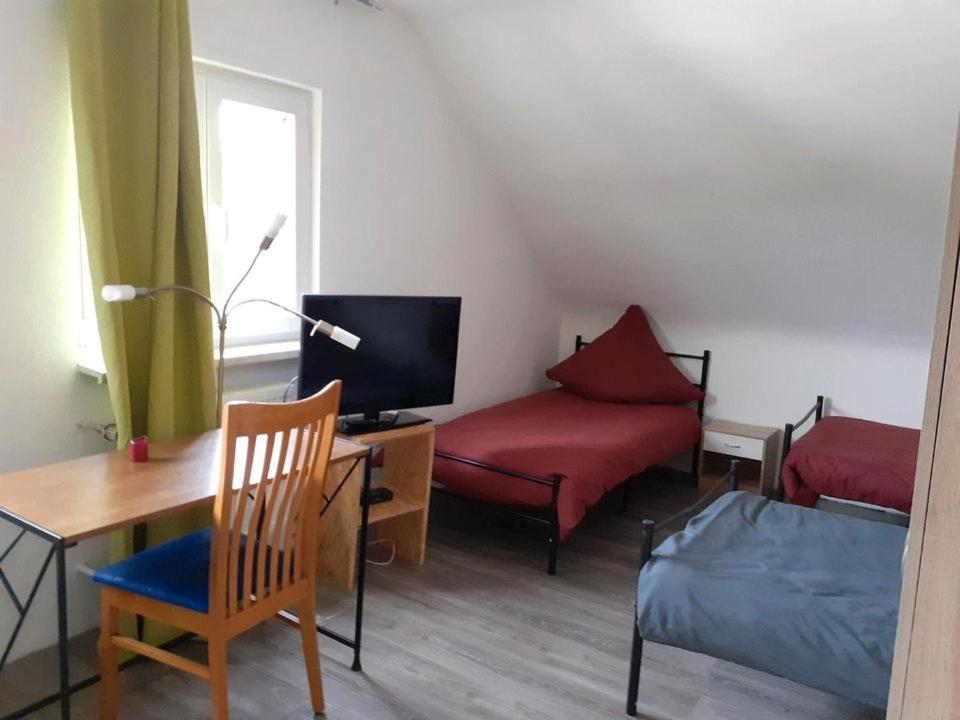 a small room with a bed and a desk with a tv at Casa Mia Russotto 4 in Bruchköbel