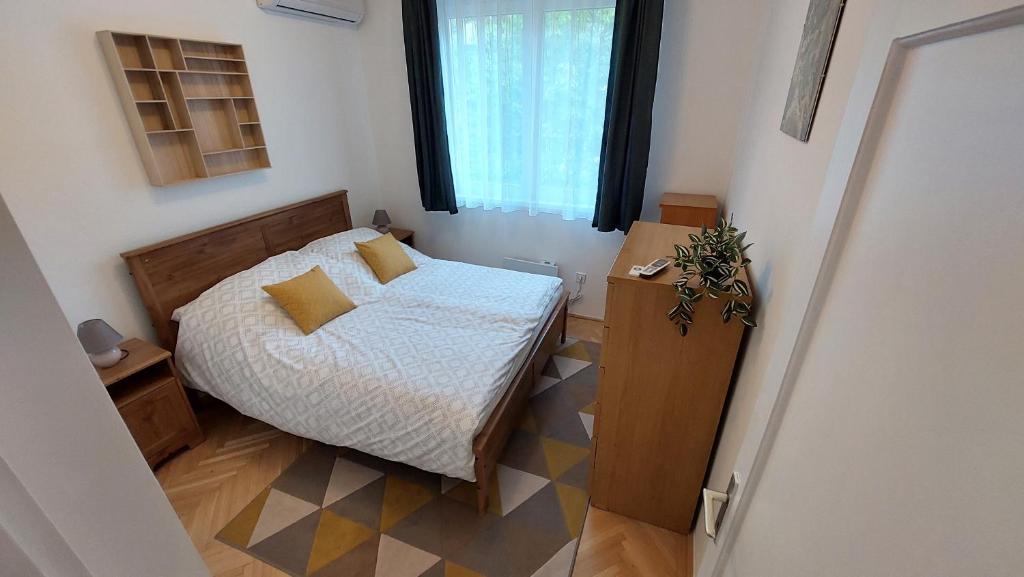 a small bedroom with a bed and a window at Comfy and stylish jewelry box in Budapest