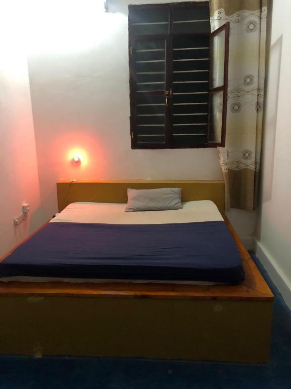 1 dormitorio con 1 cama con manta azul en Karibu house Studio en Zanzíbar