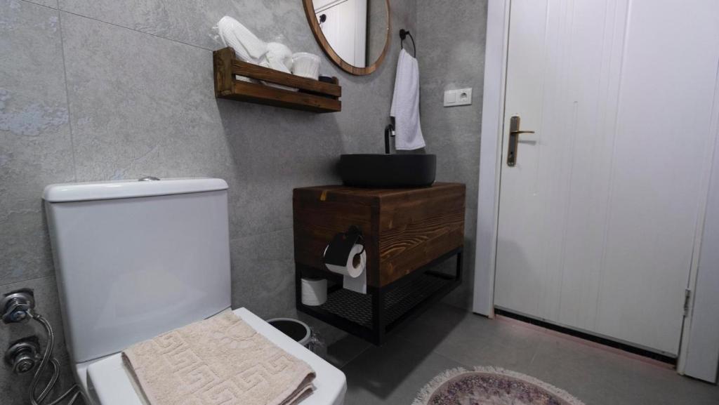 a bathroom with a white toilet and a mirror at Villa mera in Fethiye