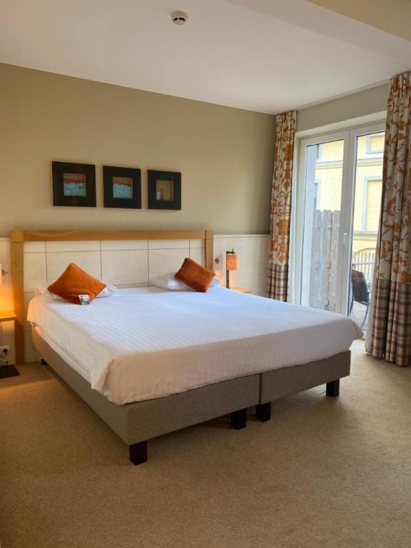 a bedroom with a large bed and a window at Castel de Pont-a-Lesse in Dinant