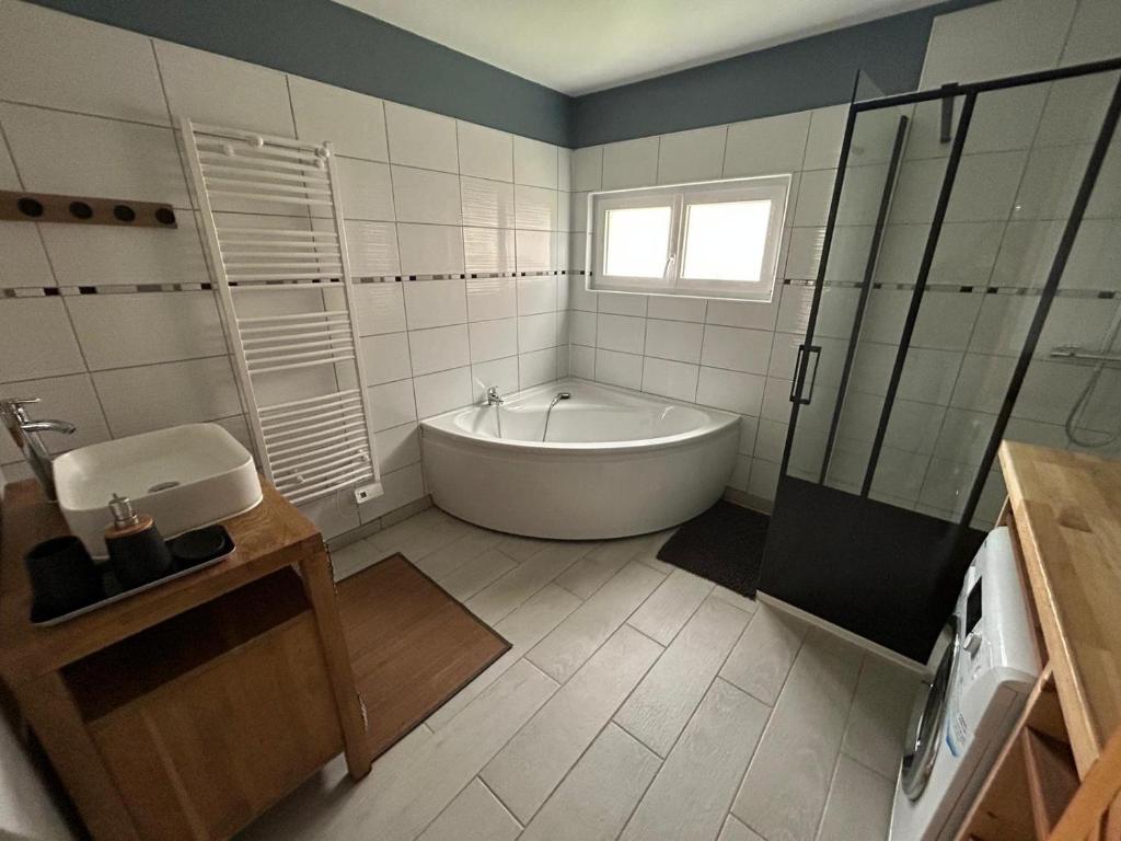 een witte badkamer met een bad en een wastafel bij La Nora Jolie in Tocqueville-sur-Eu