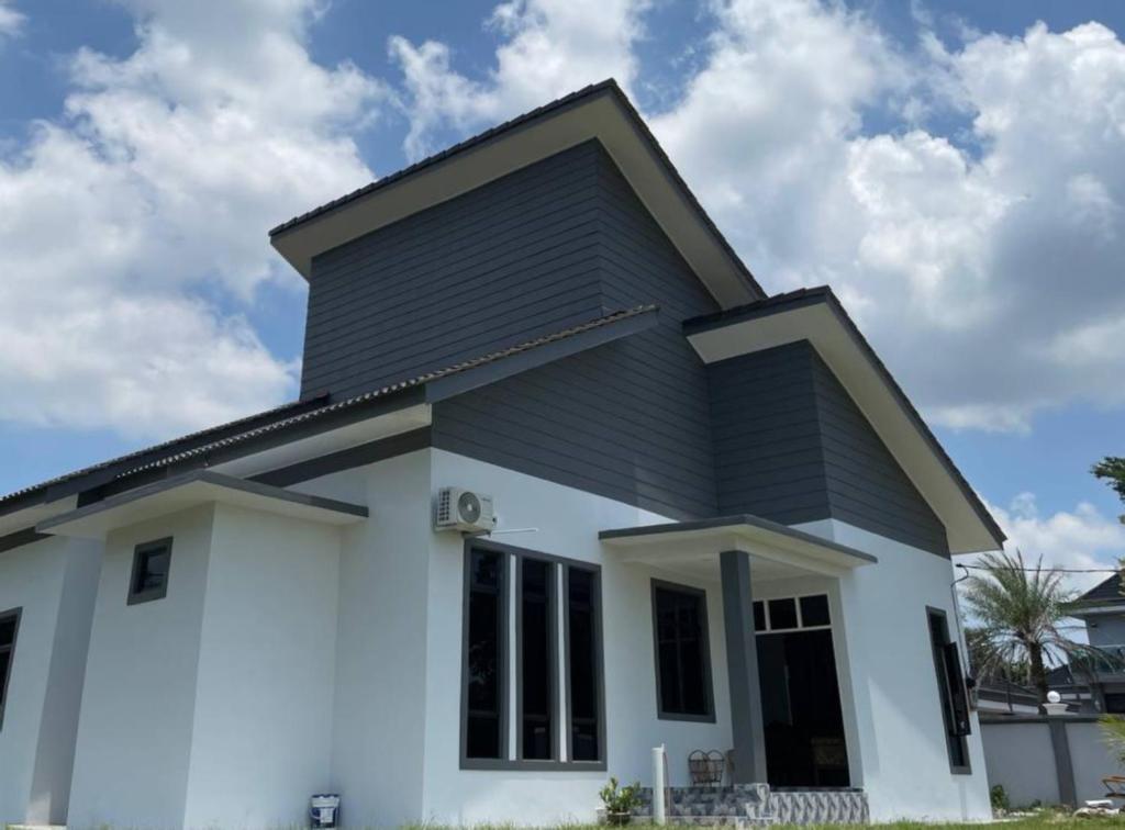 a house with a black roof at Homestay PCB Villa MamaKaya in Kota Bharu