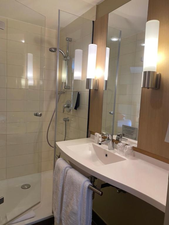 a bathroom with a sink and a shower with a mirror at Castel de Pont-a-Lesse in Dinant