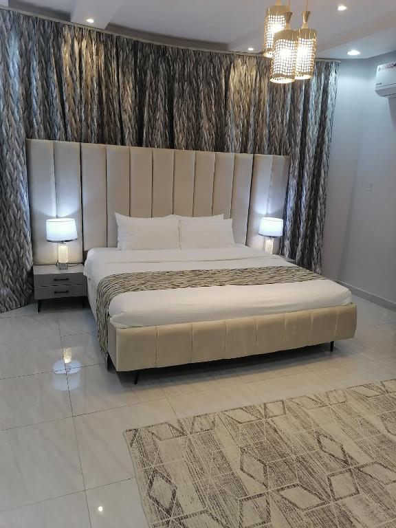 1 dormitorio con 1 cama grande y 2 lámparas en غرفة بمساحة واسعة حي الرمال en Riad