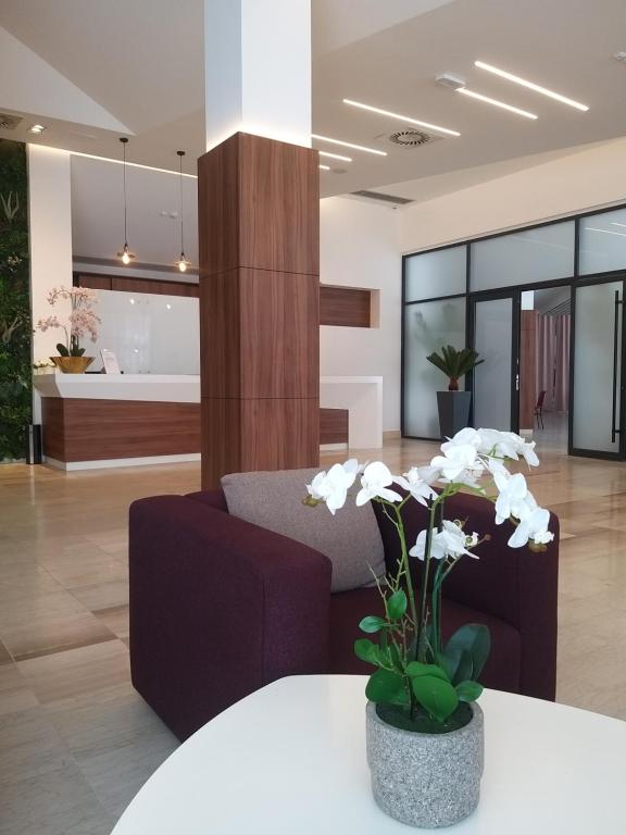 a lobby with a couch and a table with flowers at Prenoćište SRBIJA in Surdulica