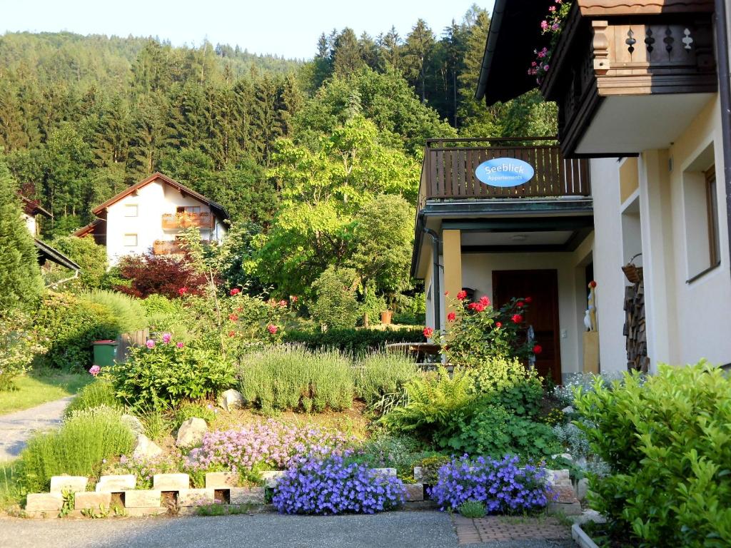 um jardim em frente a uma casa com flores em Seeblick-Appartements Ossiach em Ossiach