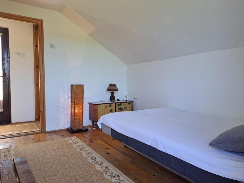 a bedroom with a large white bed and a window at Kuća za odmor Jutro in Kremna