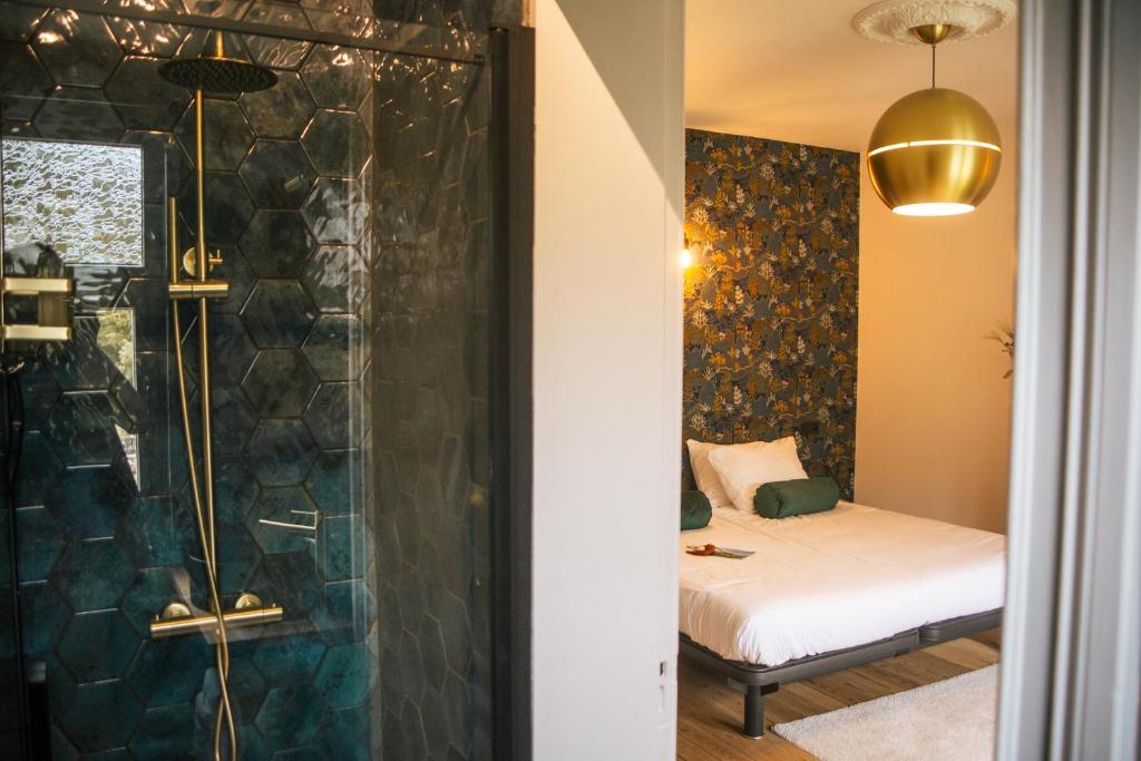 a bathroom with a shower and a bed in a room at B&B het Notarishuis in Voeren