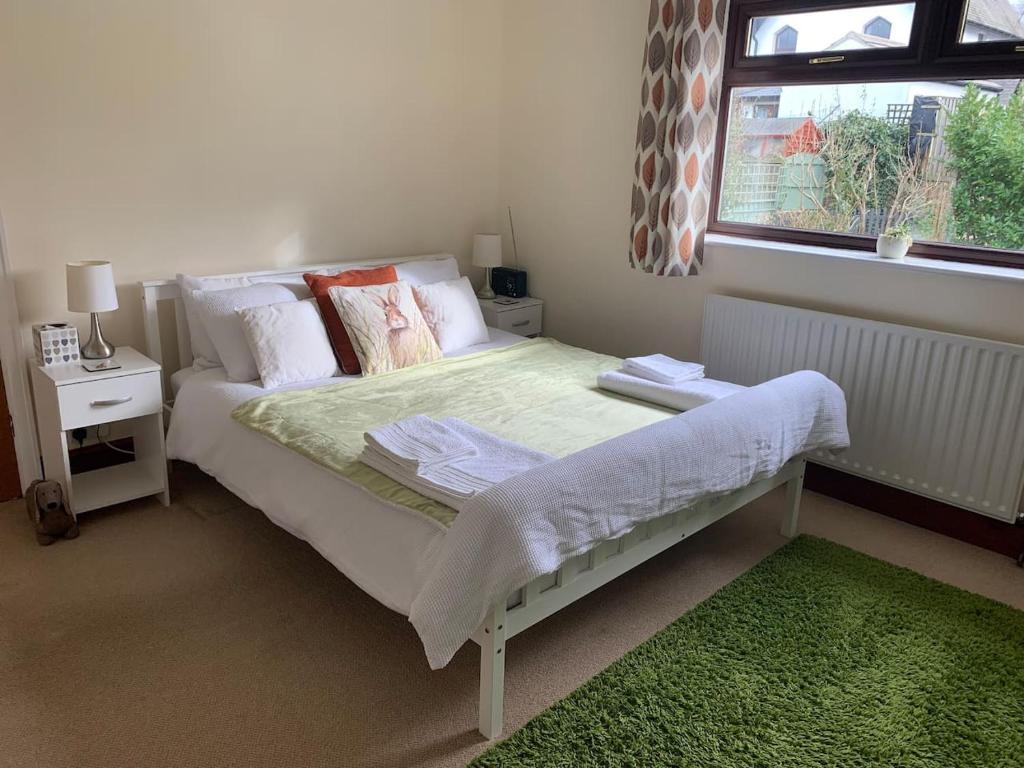 a bedroom with a bed with a green rug and a window at Self Contained Guest Suite in South Milford