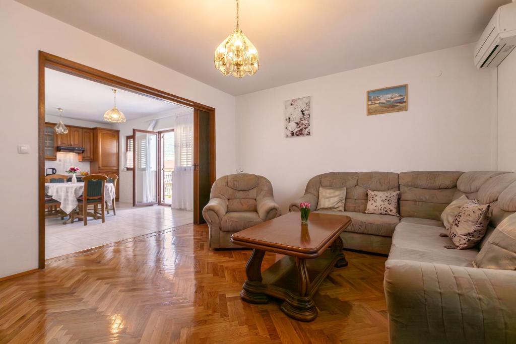 - un salon avec un canapé et une table dans l'établissement Apartman Dugeč, à Kaštela