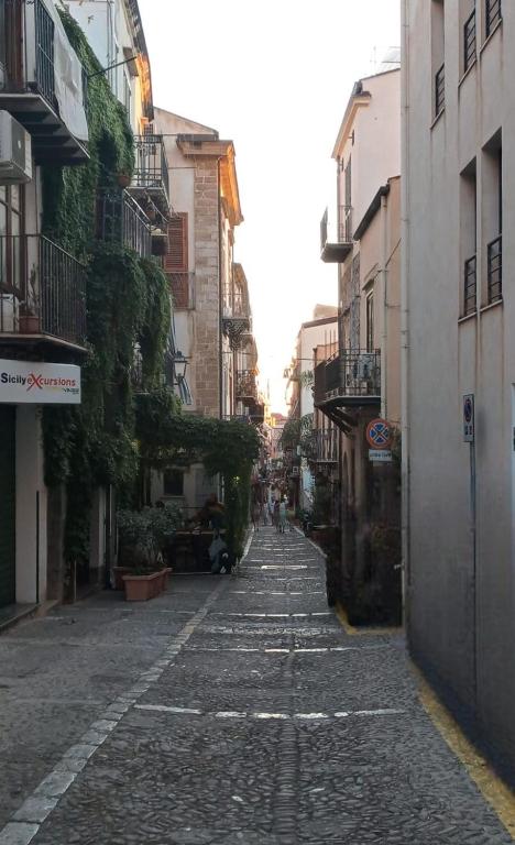 an empty street in an alley between buildings at A due passi dal Duomo in Cefalù