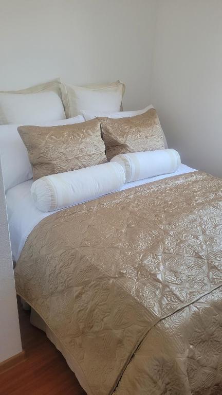 a bed with white sheets and pillows on it at Domo I Gago in Sukošan