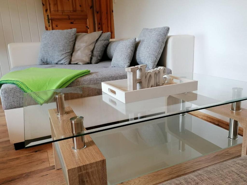 - un salon avec un canapé et une table en verre dans l'établissement Talblick im Haus (R)Auszeit, à Wildemann