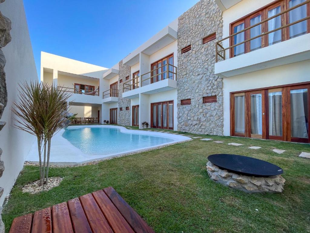 a villa with a swimming pool in a yard at Pousada Veleiro Kite Preá in Prea