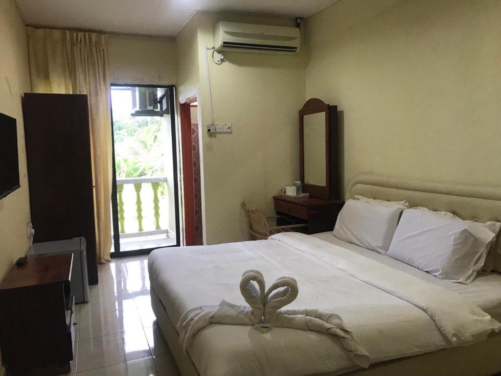 a bedroom with a bed with a heart decoration on it at ANZ LANGKAWI INN in Pantai Cenang