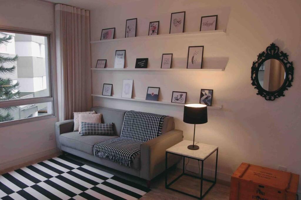 uma sala de estar com um sofá e um espelho em ALTO PADRÃO centro de Criciúma em Criciúma