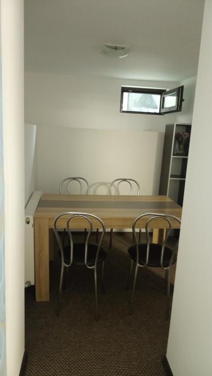 um quarto com uma mesa de madeira e 2 cadeiras em Karina House em Brasov