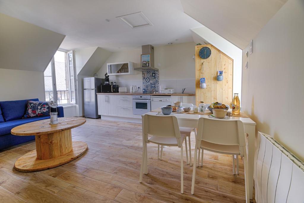 une cuisine et un salon avec une table et des chaises dans l'établissement Duplex Le Louisels, à Bayeux