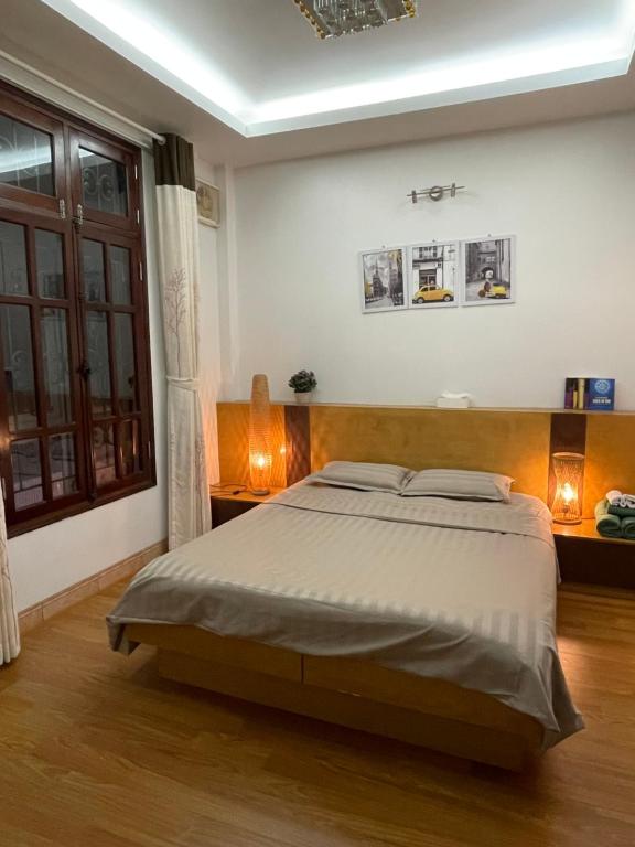 um quarto com uma cama grande e uma janela em Hidden gem homestay 2 em Hanói