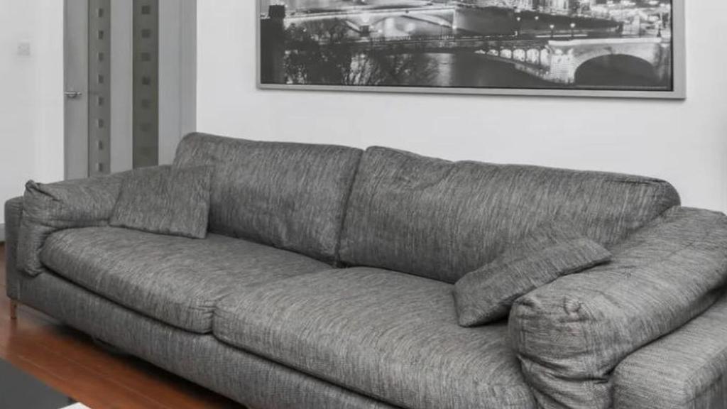 - un canapé gris dans le salon dans l'établissement Garmisch Karwendel Ferienhaus, à Garmisch-Partenkirchen