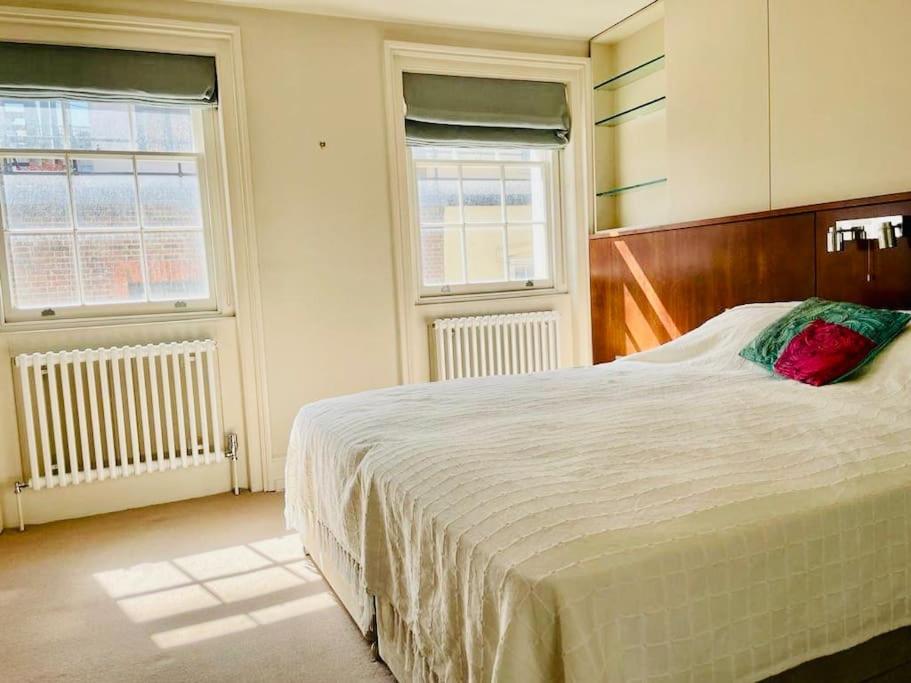 - une chambre avec un grand lit et 2 fenêtres dans l'établissement Charming central home by iconic landmarks nr, à Londres