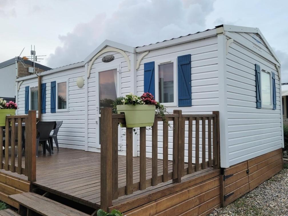 a white tiny house with a wooden deck at le Petit futé 112 in Biville-sur-Mer