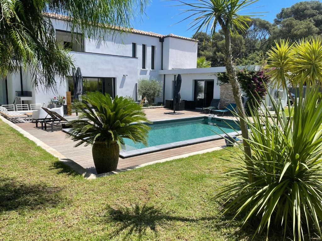 une villa avec piscine et palmiers dans l'établissement Le Minamo Studio, à Six-Fours-les-Plages