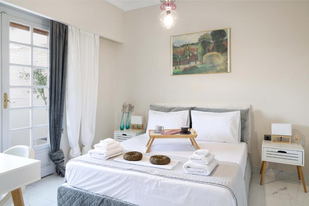 Un dormitorio blanco con una cama con toallas. en The Terrace Kiss, en Atenas