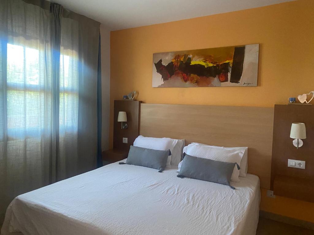1 dormitorio con 1 cama blanca y 2 almohadas en Apartamento Punta Umbría Parking Incluido y Piscina en Punta Umbría