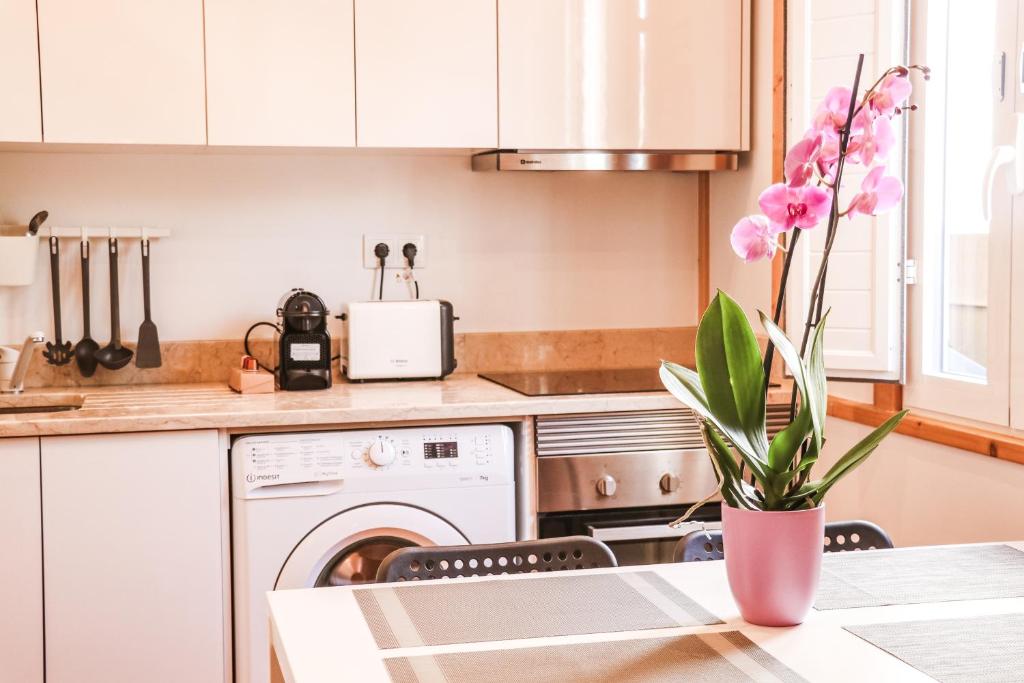 a kitchen with a table with a vase of flowers at Golden Place - Cacilhas in Almada